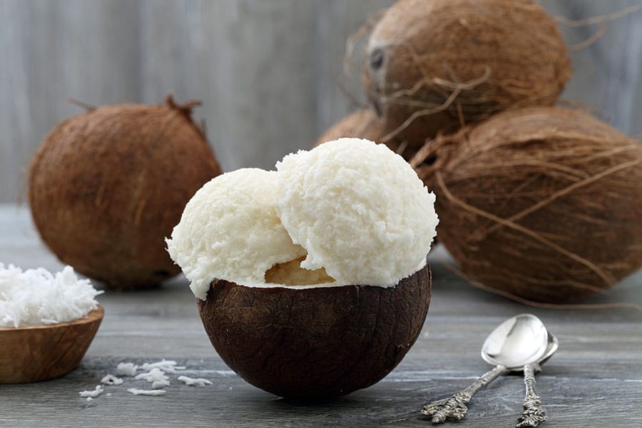 Домашен кето сладолед от кокосово масло и кокосово мляко в купа от кокосов орех.