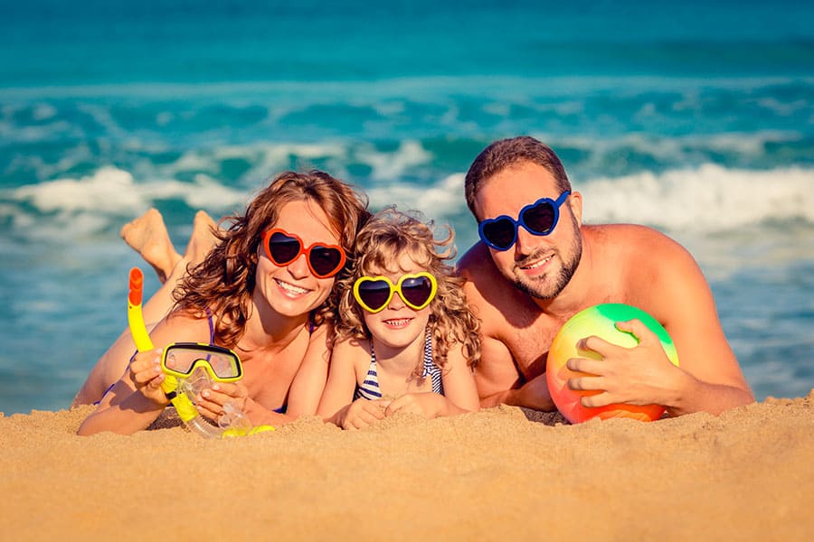 Витамини за лятото. Семейство млади хора, щастливи на плажа по време на лятната им почивка. Омега 3 за деца.