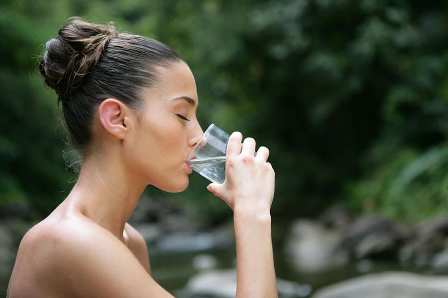 Момиче пие чаша вода, и таблетка цинк до воден ресурс.