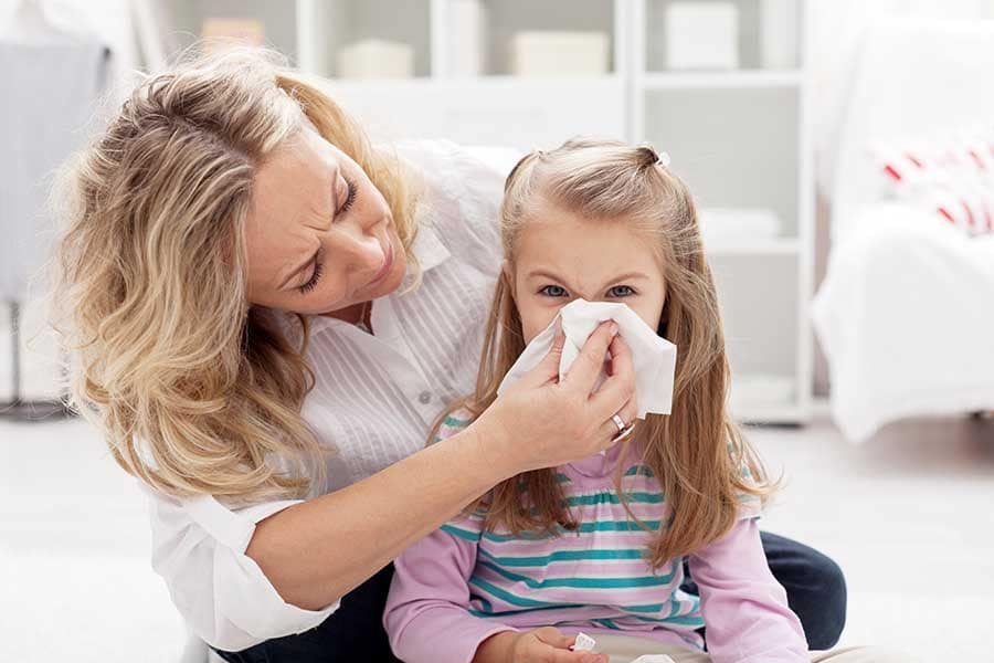 Прием на витамин D3 при грип спомага облекаването на настинката - майка, която се грижи за настинало дете.