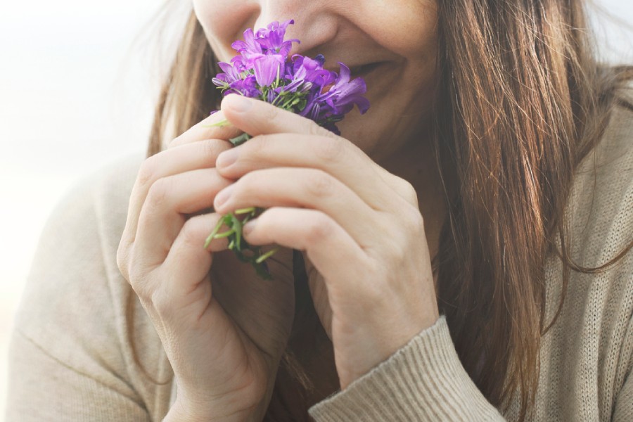 Жена мирише цветята на баховите есенции.