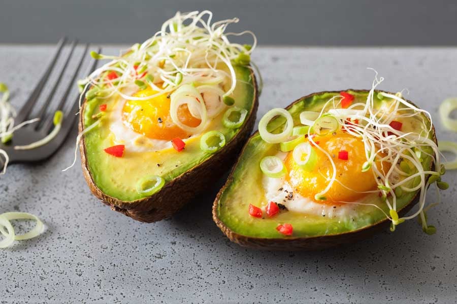кълнове от люцерна върху авокадо с яйце