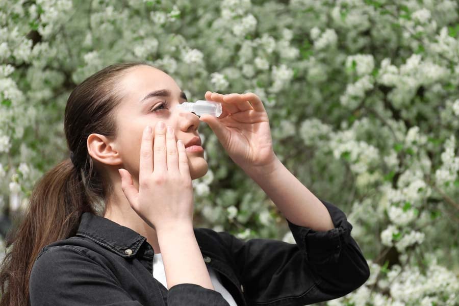 жена с алергичен конюнктивит използва капки за очи