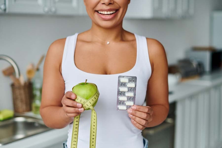 жена държи хапчета за отслабване