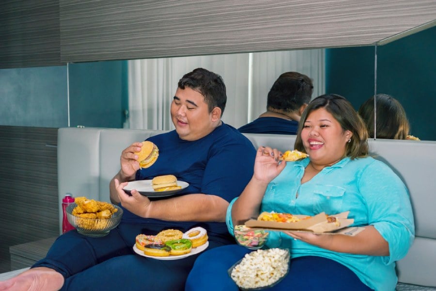 митове за метаболизма, двойка с наднормено тегло яде джънк фуд